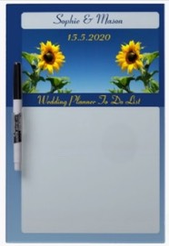A wedding planner board. A dry erase board with sunflowers against a blue sky with the couple’s names and space for the things to do before the day they say ‘I do’